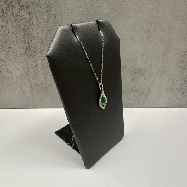 This elegant emerald and diamond necklace in 10kt yellow gold features a vivid pear cut emerald measuring approximately...