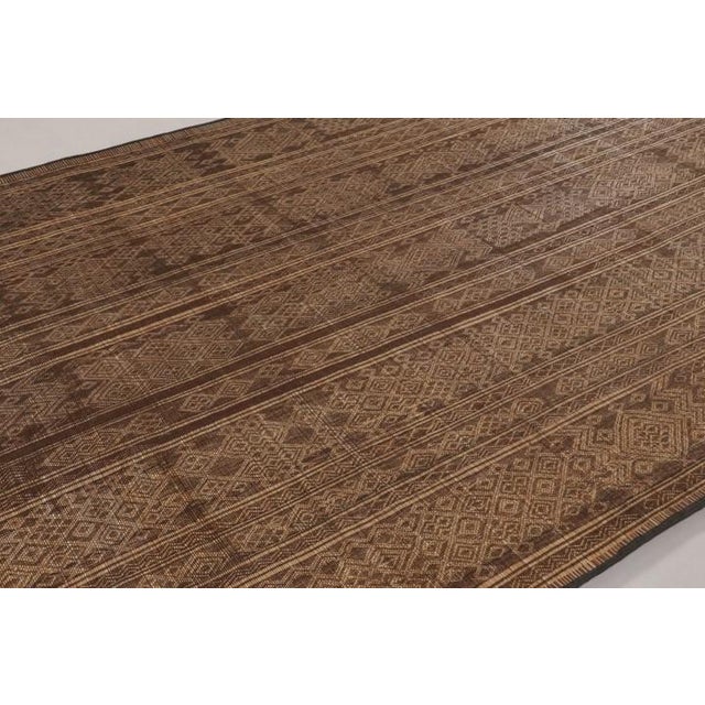 Made with handwoven reed and camel leather in Mauritania circa 1950-1960, this 8x11 vintage Tuareg mat is an exceptional...