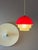 This red plastic pendant lamp in a space-age style impresses with its striking red dome and futuristic design. The...