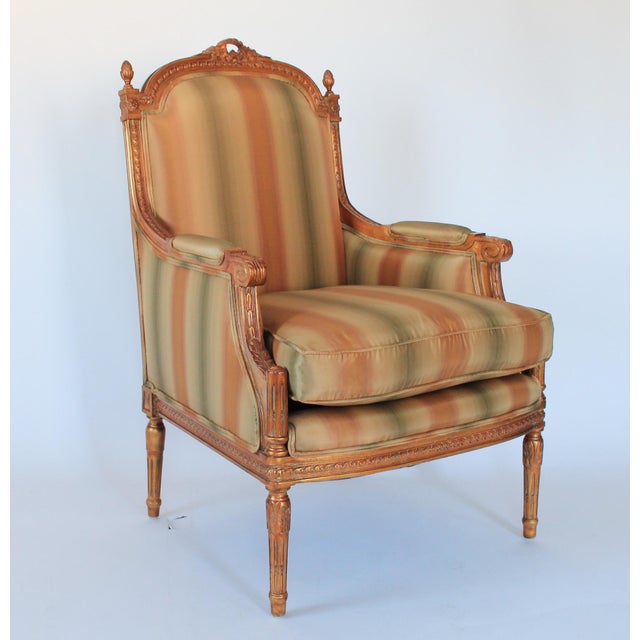 Louis XVI Style Upholstered Bergere, with fluted legs and striped upholstery. No makers mark. It appears to have been...