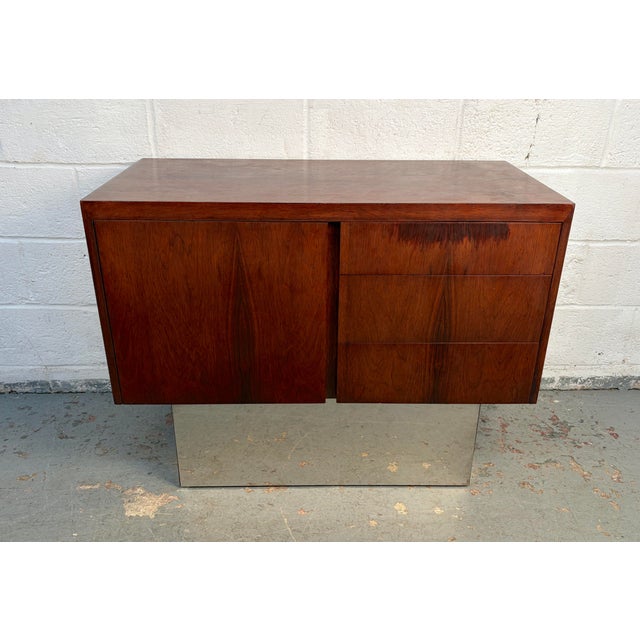 A striking Mid-Century Danish credenza crafted from richly figured rosewood and accented with a sleek chrome base. This...