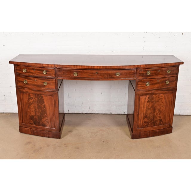 A stately antique Georgian or Chippendale style bow front sideboard or credenza England, Circa 1820 Gorgeous flame...