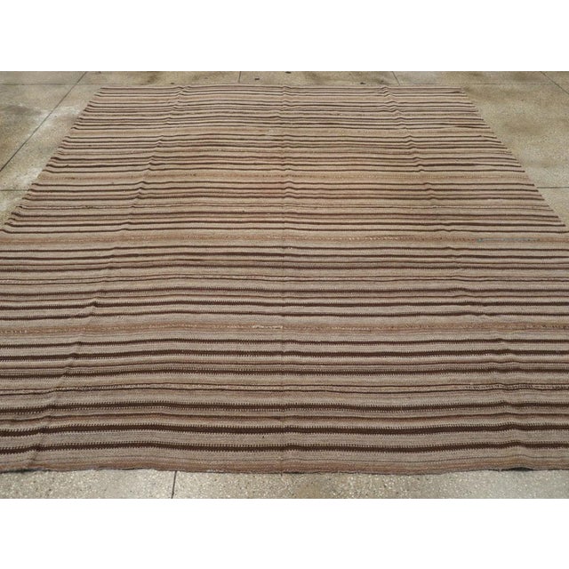 This Mid-20th century Turkish Flatweave Kilim rug, showcases the rich heritage of Anatolian textile artistry. Its design...