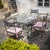 Garden seating set in iron consisting of a table with a rectangular glass top and four matching chairs in an antiqued...