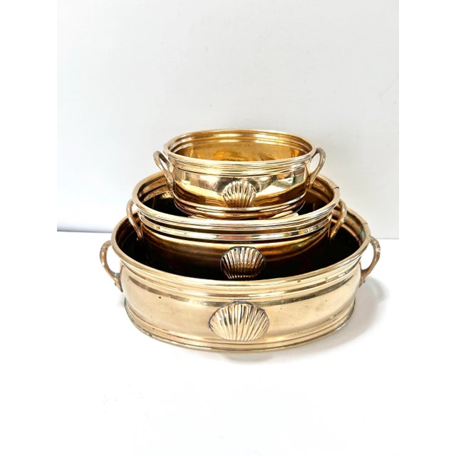 A wonderful, instant collection of brass planters. Each is relief embossed with a single seashell. All three are in...