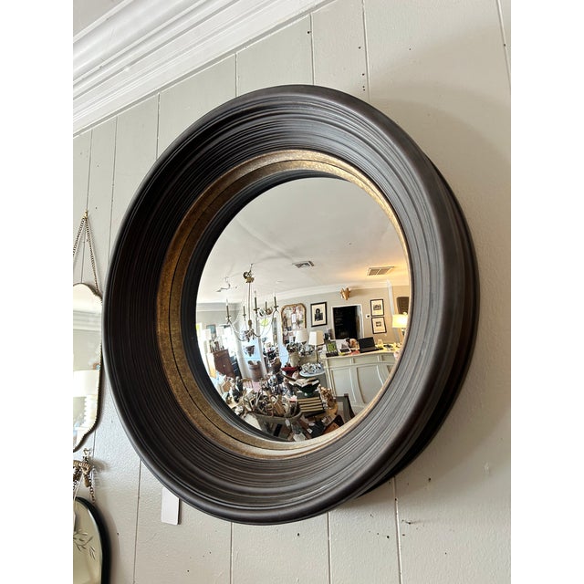 Vintage Style. Ribbed concave frame with a mottled gold leaf inset and convex mirror in the center. The contrasting black...