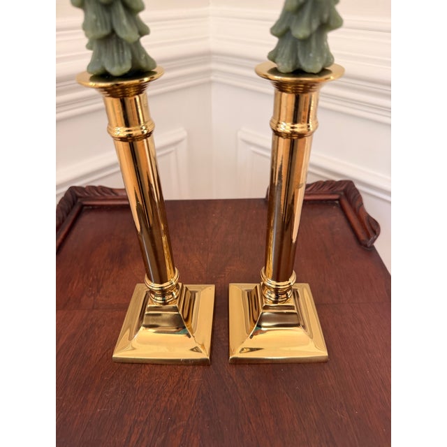 Elegant pair of vintage polished brass candlesticks featuring classic column-form stems and substantial square stepped...
