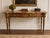 An elegant vintage console table by John Widdicomb, featuring a richly ornamented Neoclassical design and substantial...