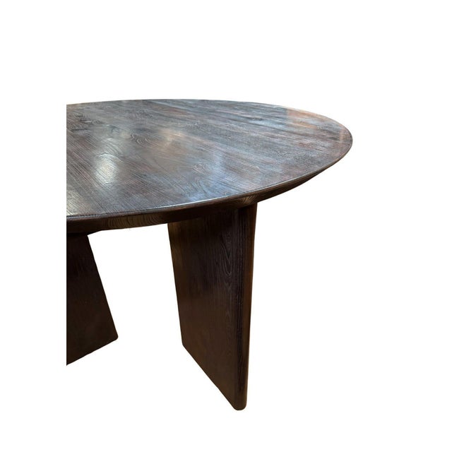 This reclaimed teak wood dining table combines timeless craftsmanship with modern sculptural design. The rich, dark-toned...