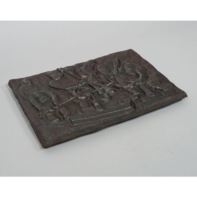 A large and heavy cast iron plaque entitled ‘Foundrymen’ (1991), by British artist, Anna Bisset (1965-). In a style...