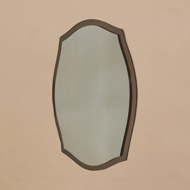 An Italian bronze-tinted wall mirror attributed to Cristal Arte, dating to the 1970s. The gently contoured silhouette is...