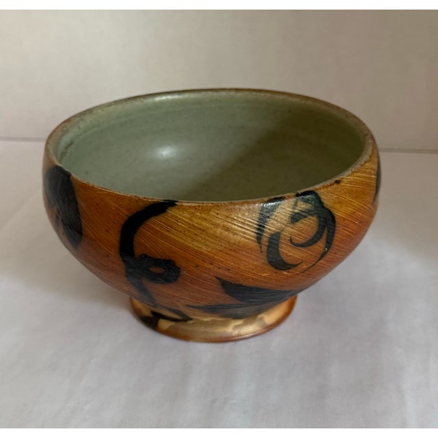 Folk-style brushwork using the slip technique. The artist's signature is present on the side. Height unknown Diameter = 7"