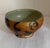 Folk-style brushwork using the slip technique. The artist's signature is present on the side. Height unknown Diameter = 7"