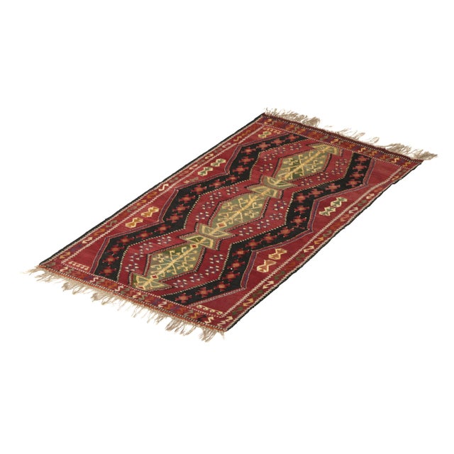 Handmade in a wool flat weave originating from Turkey circa 1910-1920, this antique Kilim rug enjoys the rare addition of...
