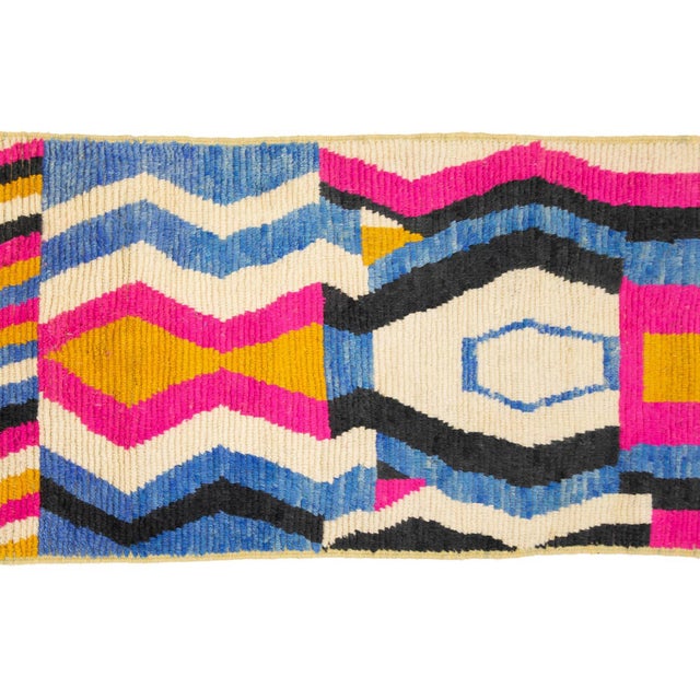 A visual rhythm of shape and color, from top to bottom. This hand-knotted wool runner reads like a kaleidoscope unspooled...