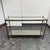 Design Plus Gallery presents a Vintage Hollywood Regency Metal + Glass Console Table. This late 20th-century console is...