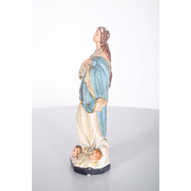 Portuguese sculpture of Nossa Senhora da Imaculada Conceição. with hands clasped, white robes and a beautiful light blue...