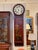 19th century chinoiserie wall clock with a white dial and Roman numerals in a carved round bezel, over a red case...