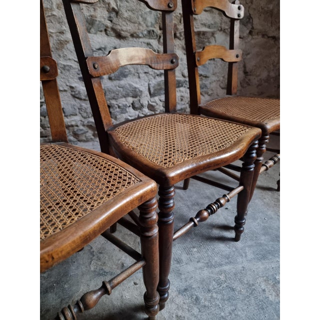 Set of four antique dining chairs dating from around 1900–1920. The chairs are made of solid beech and feature woven cane...