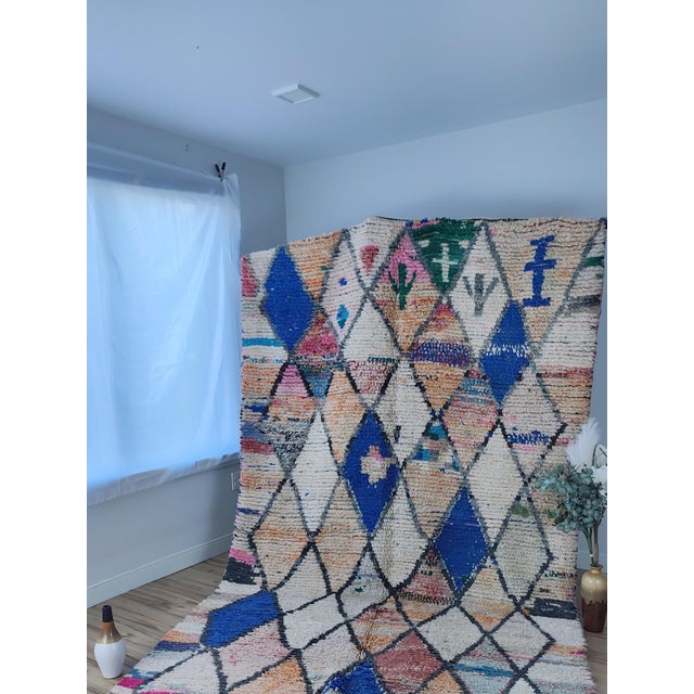 A contemporary Boujaad rug hand-knotted by Berber artisans in Morocco. An ivory ground is crossed by a full diamond...