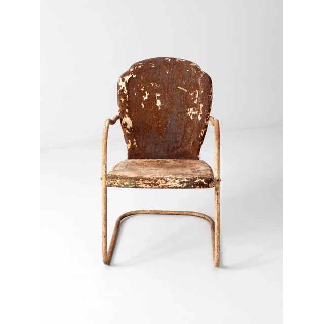 This mid-century shell back lawn chair features a classic metal “bouncer” frame with a distinctive shell-shaped backrest....