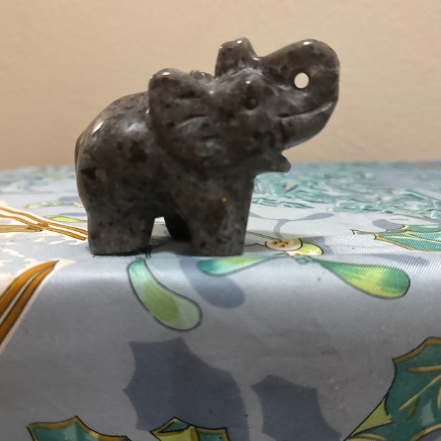 Animal carving depicting an elephant with its trunk raised, a symbol often associated with good luck, wisdom, and protection.