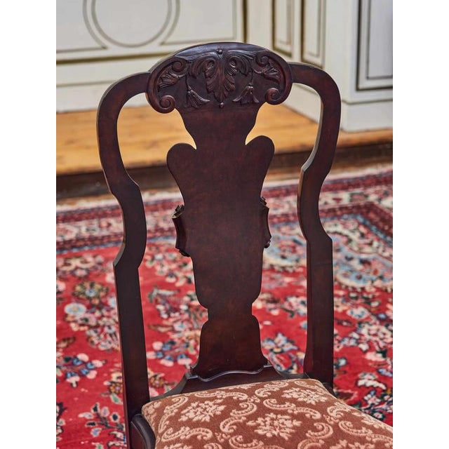 An elegant set of four dining chairs in the style of Thomas Chippendale, made in England in the first half of the 20th...