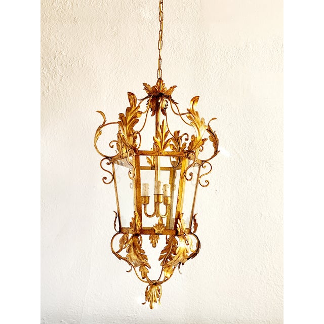 Stunning Italian Louis XVI style Gilt Iron large hanging lantern, with three center lights, four glass panels, having...