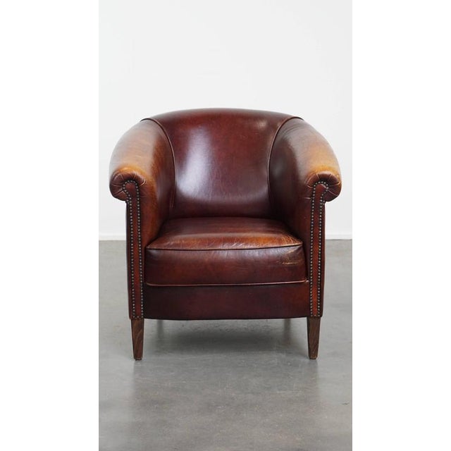 Offered this charming English-style cowhide leather club chair with a fixed seat cushion and a beautiful patina. This...