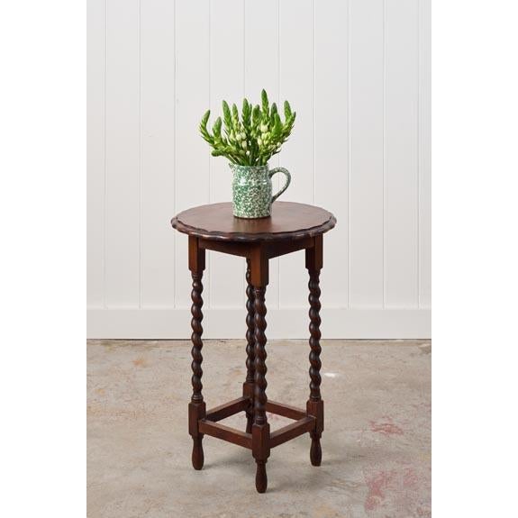 This antique English round oak side table features a circular top with a scalloped edge and barley twist legs connected by...
