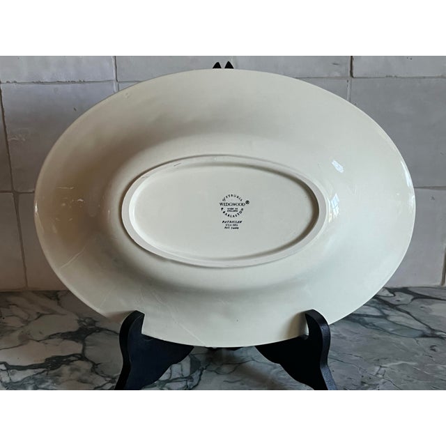 Bone China. Ivory, creamy off white, raised, embossed design around rim consisting of scrolls of flowers, leaves and vines.