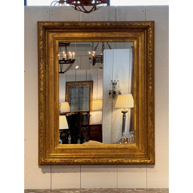 Carved and gilt wood frame with layered molding, bead and leaf detail, and inner engraved border. Rectangular form with...