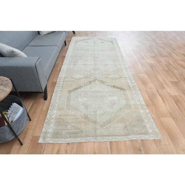Vintage Hand-Knotted runner rug is a semi-antique vintage area rug. The '70s Eastern region of Anatolia's unique rug is...