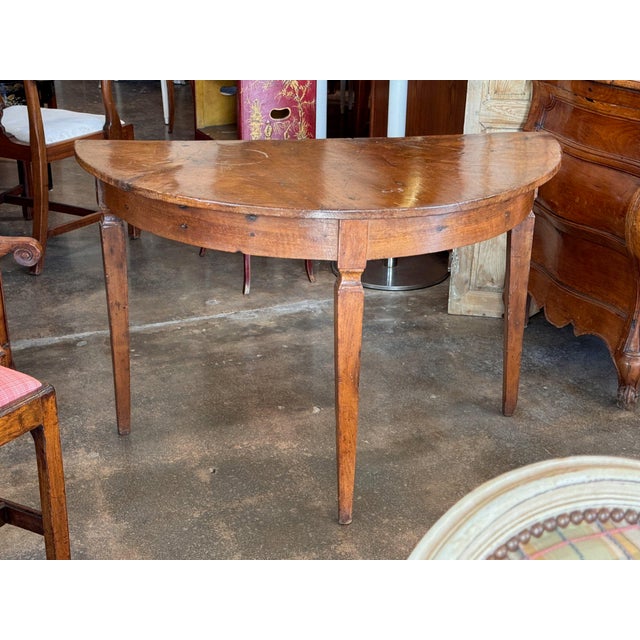 French walnut and 19th century, with a half round top over a plain apron on three square tapered legs. The top has the...