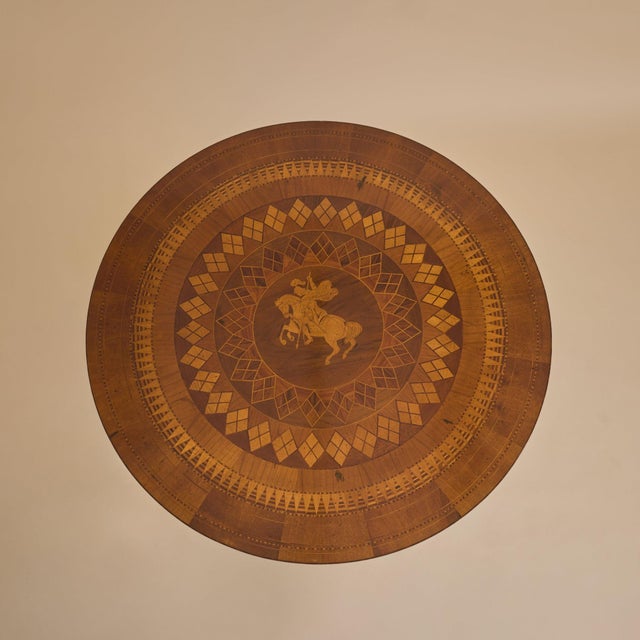A 19th Century Italian Neoclassical center table, crafted in rich walnut and adorned with exquisite marquetry. The round...