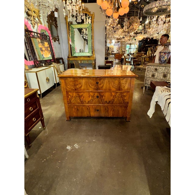 The 19th c. German Biedermeier Walnut Commode is a vintage piece of furniture that is sure to add a touch of elegance to...