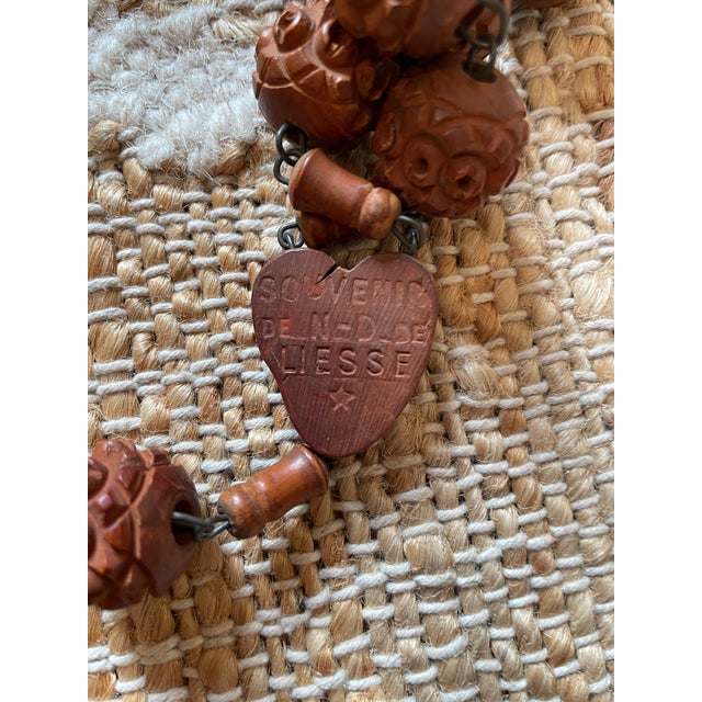 Listed is a vintage large 50-inch French rosary with carved corozo beads and a wooden cross. It is a religious item that...