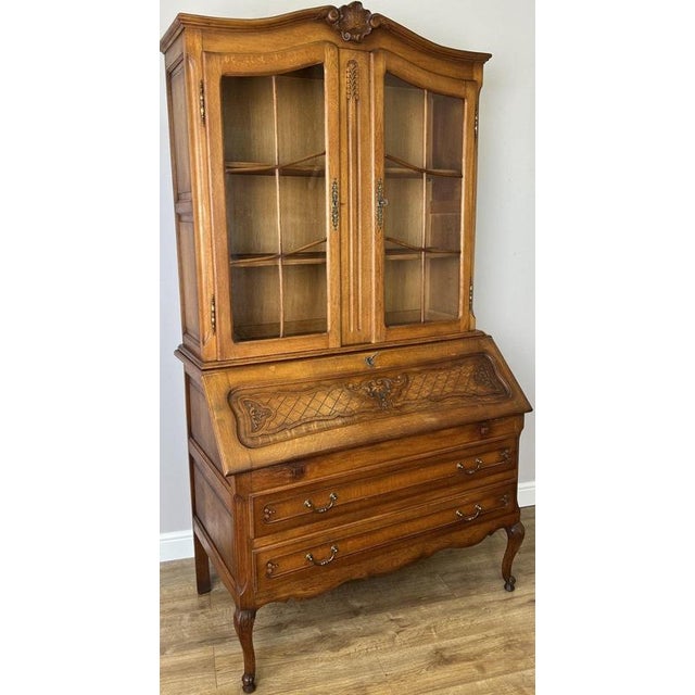 This elegant Vintage French Louis cabinet combines a glazed display cabinet with a practical fall-front bureau, creating a...
