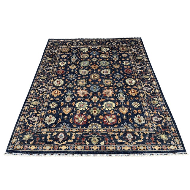 This Afghan Sultani wool area rug features a deep navy blue field filled with Persian-inspired floral and botanical...