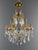 An elegant louis xv style chandelier with six lights, crafted from gilt brass and richly adorned with numerous crystal...