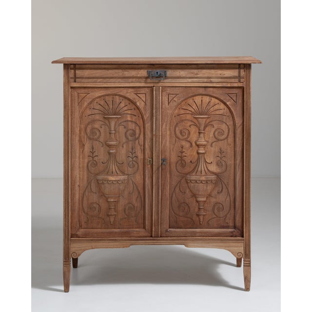 A richly carved walnut buffet reflecting the continuation of traditional French craftsmanship into the mid-20th century,...
