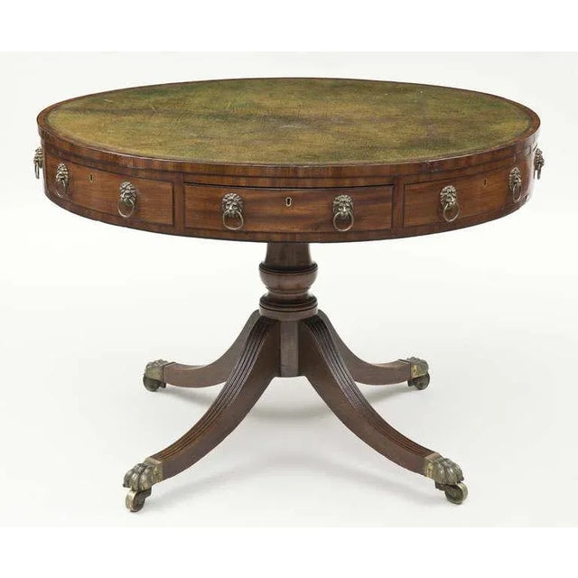 Regency period mahogany revolving drum table with olive green gilt-tooled leather top, the frieze fitted with alternating...