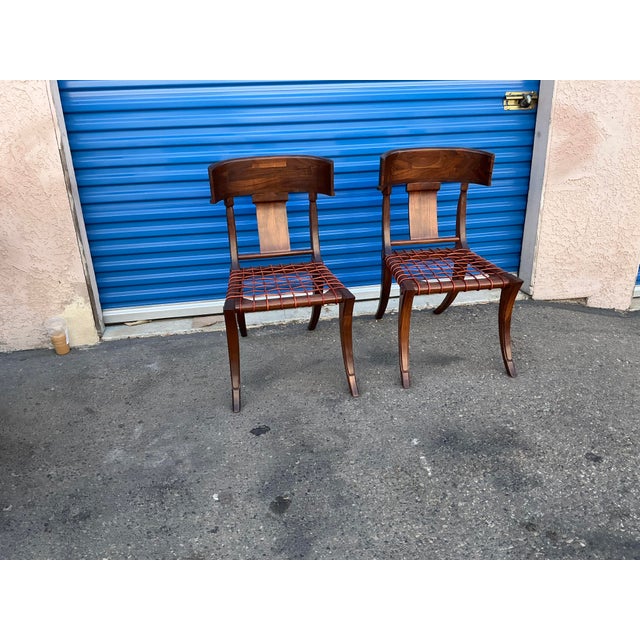 Pair of walnut Klismos chairs. Chairs are solid walnut. Finish is done in a matte natural walnut. Chairs are flawless and...