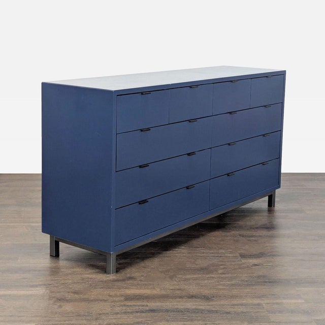 This Room & Board dresser features a sleek navy finish and modern design. It has 10 spacious drawers that glide smoothly,...