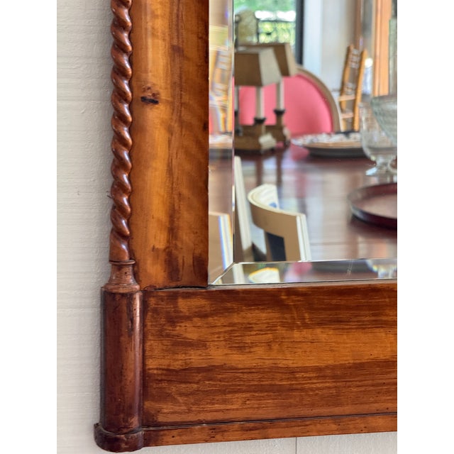 A 19th century Biedermeier birch mirror, the shaped crest over a figured birch panel with an inlaid line border, rope-...