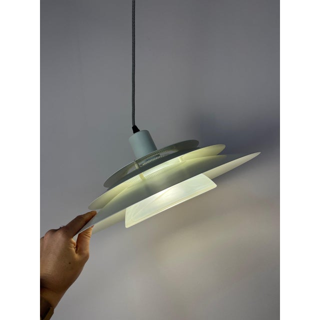 This white louvered lamp from Jeka is a Danish mid-century classic that surprises with a truly special design detail. Jeka...
