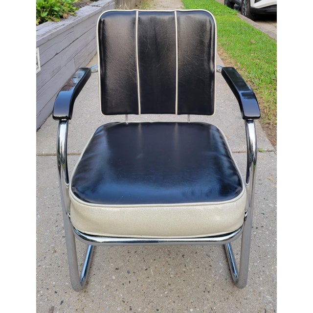 This streamline Art Deco springer club chair features gorgeous jet black wood armrests and vinyl upholstery with white...