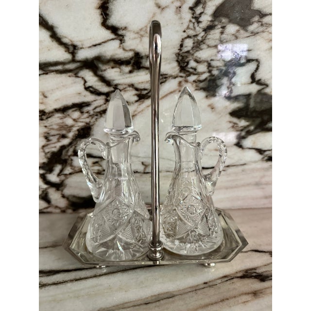 Vintage European silver plated caddie with two oil and vinegar faceted crystal bottles. No maker’s marks.