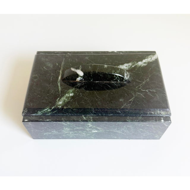A sculptural green marble lidded box featuring dramatic veining in deep green and soft white tones. Crafted from solid...