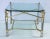 A fine French low table featuring a square canted and beveled edge clear glass top, set upon a chrome and gilt metal base...
